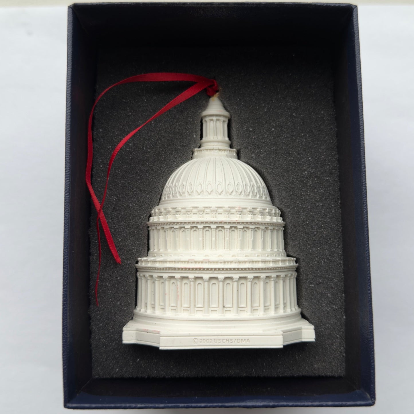 Model of the U.S. Capitol building in a box with a red ribbon