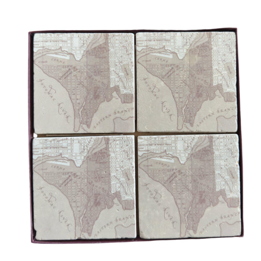 Set of four square tiles with engraved map design on a wooden surface